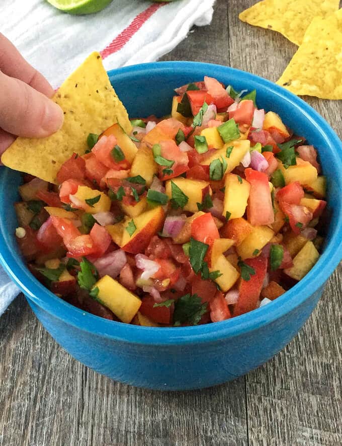This Peach Salsa recipe is made with sweet fresh peaches and tomatoes. It makes a tasty dip for tortilla chips, but it's also a delicious topping for fish or pork!