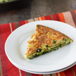 A slice of Hash Brown Frittata sitting on a small white plate.