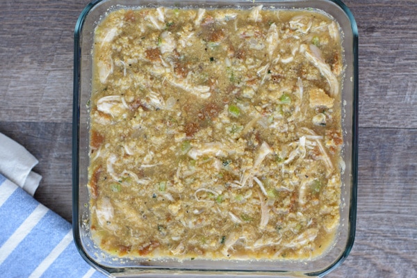 A square glass dish of Chicken and Dressing before baking. 
