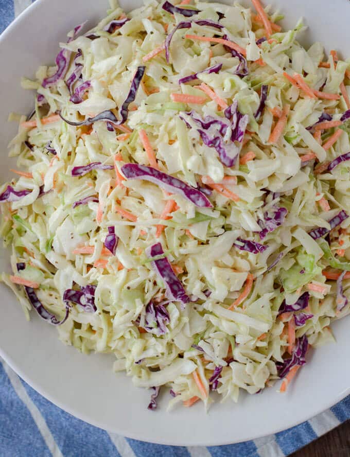 A large bowl of healthy coleslaw sitting on a towel. 