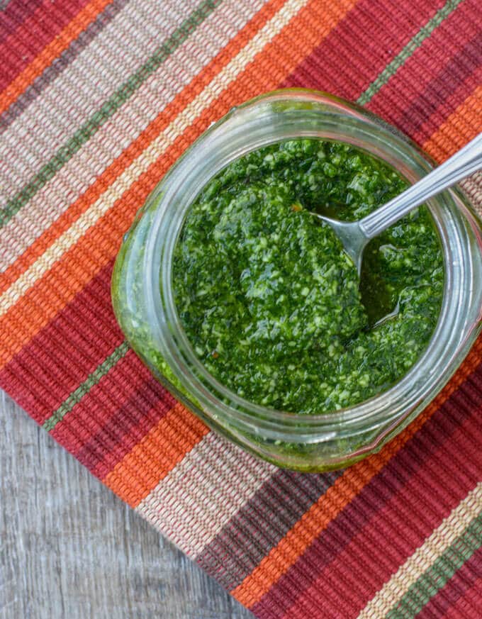 A close up view of a spoonful of pesto.